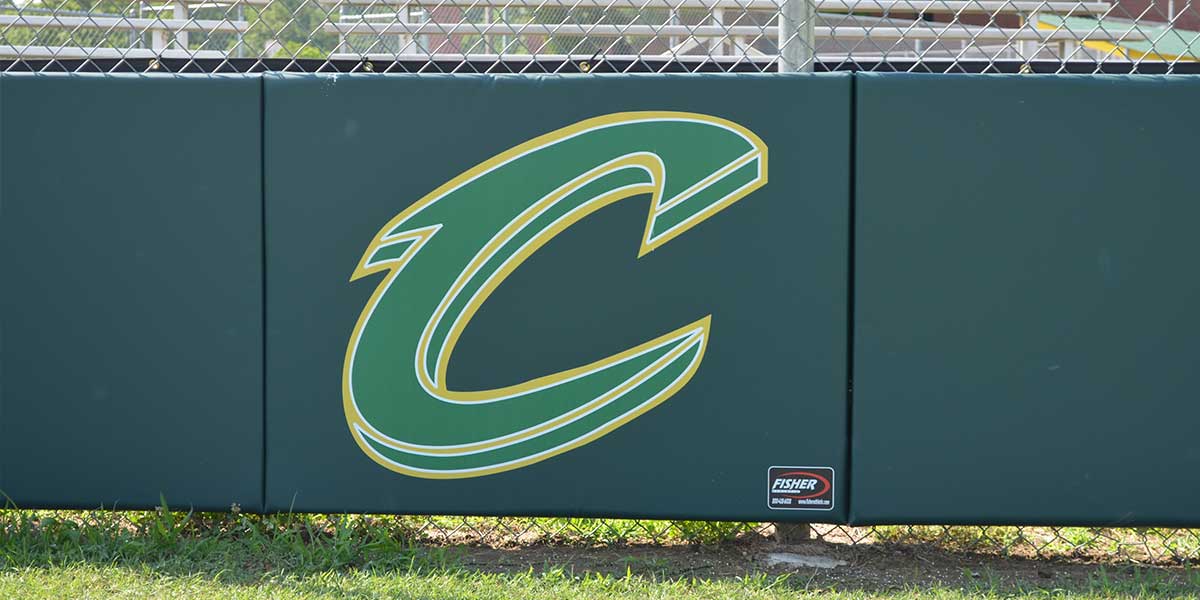 Close view of a green grommeted fence pad with a printed C logo on a chain link fence