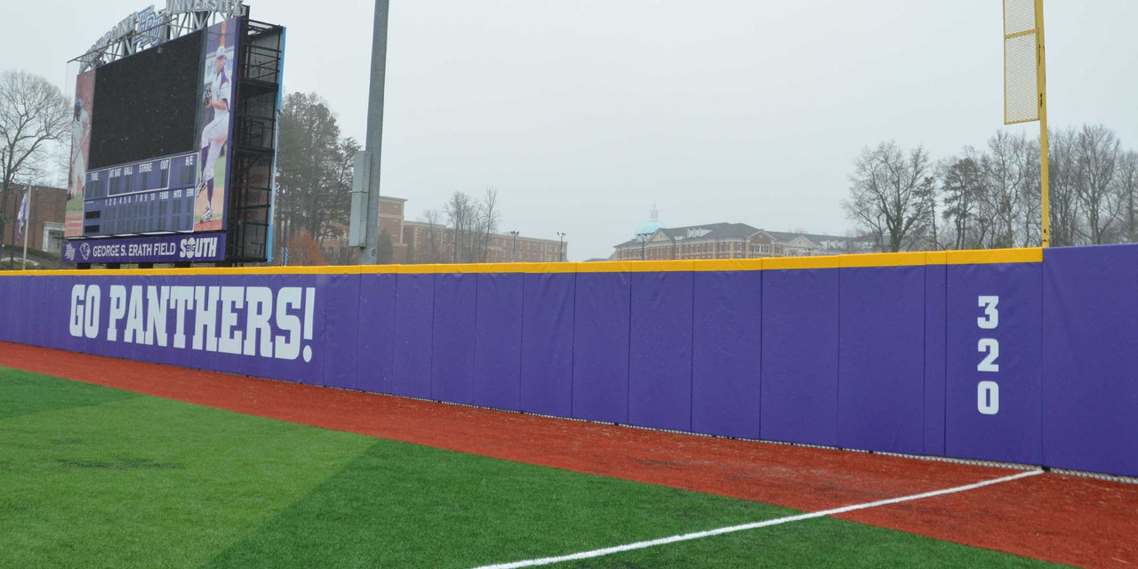 Purple outfield wall padding printed with Go Panthers and a 320 distance marker