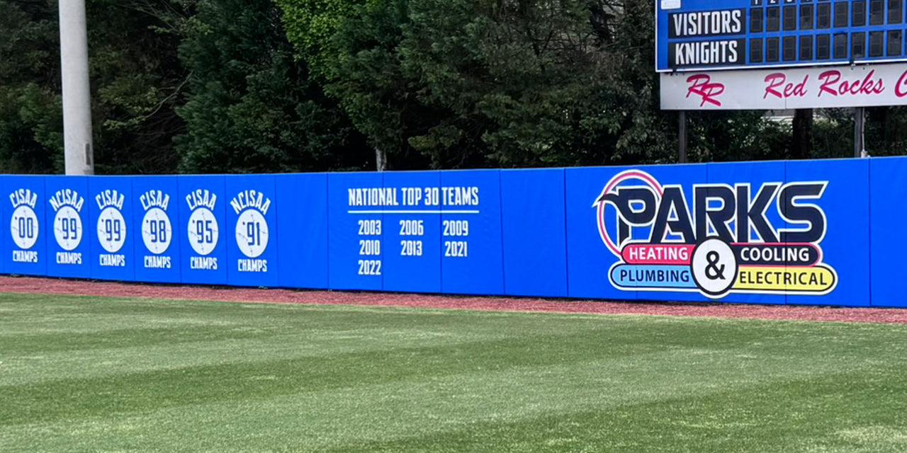 Blue outfield wall padding printed with championship years and a sponsor logo