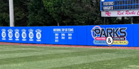 Thumbnail for Blue outfield wall padding printed with championship years and a sponsor logo