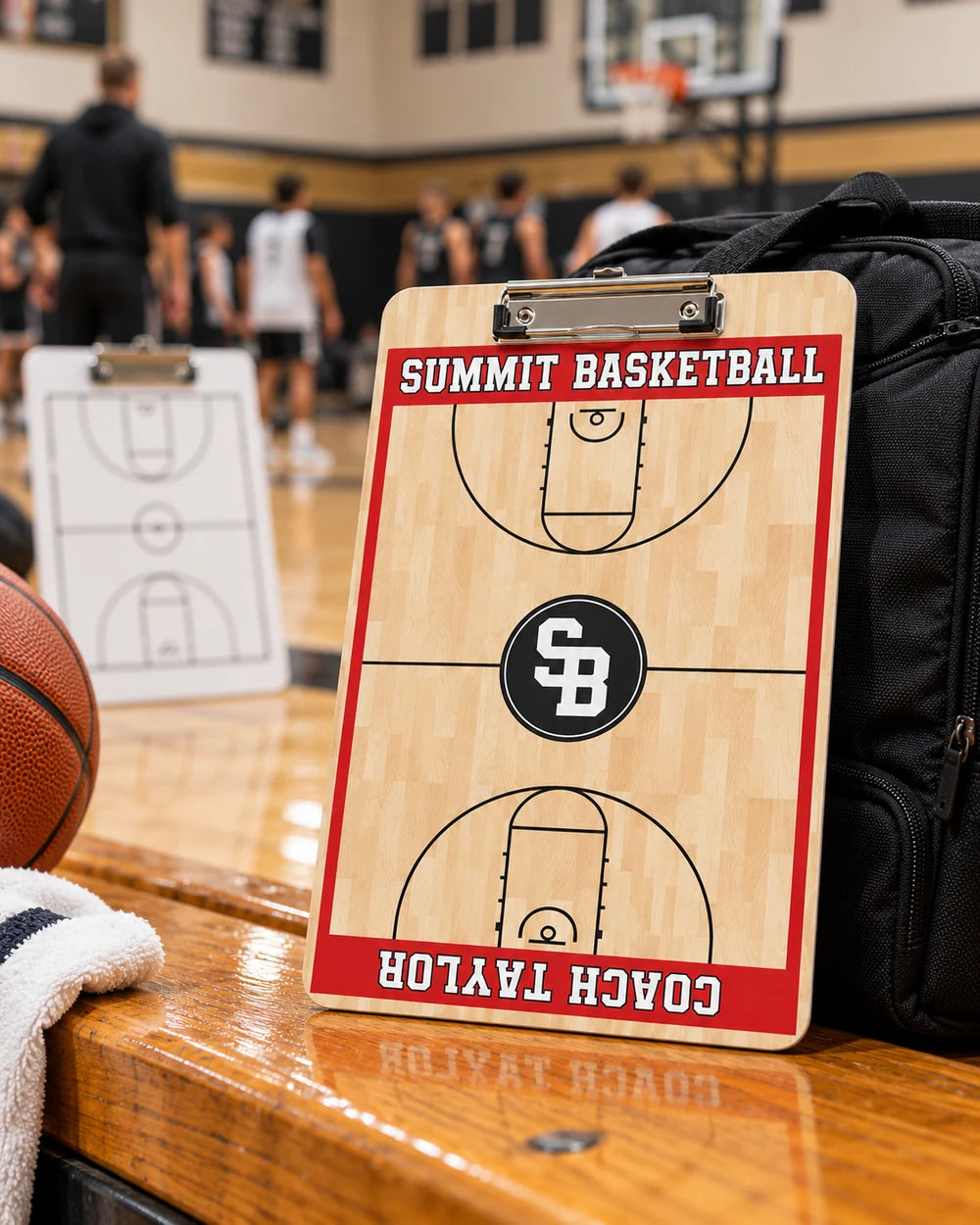 Custom Summit Basketball portrait clipboard with a metal paper clip on a courtside bench in a school gym
